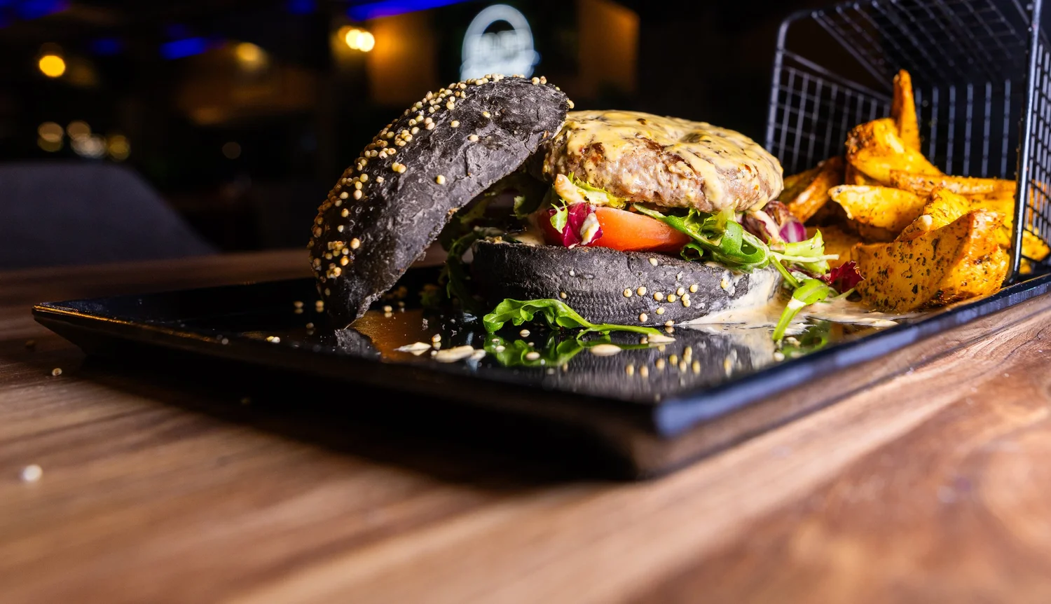 Elit Burger au pain noir servi avec des potatoes